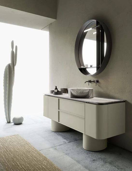 Mobile bagno color avorio con lavabo in pietra e specchio ovale